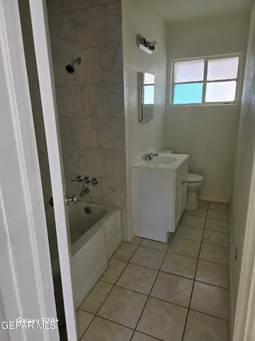 a bathroom with a bathtub a sink a window and a shower