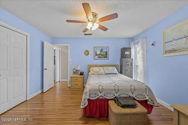 a bedroom with a bed and wooden floor