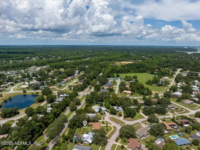 an aerial view of residential houses with outdoor space and trees