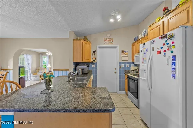 a kitchen with stainless steel appliances granite countertop a refrigerator and a sink