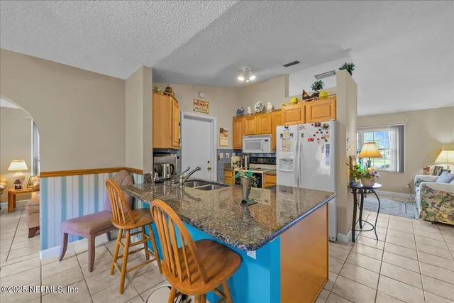 a kitchen with granite countertop kitchen island stainless steel appliances a table and chairs