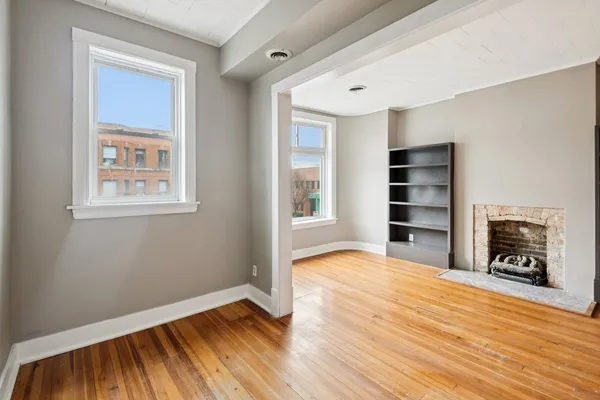 a view of a livingroom with wooden floor and a fireplace