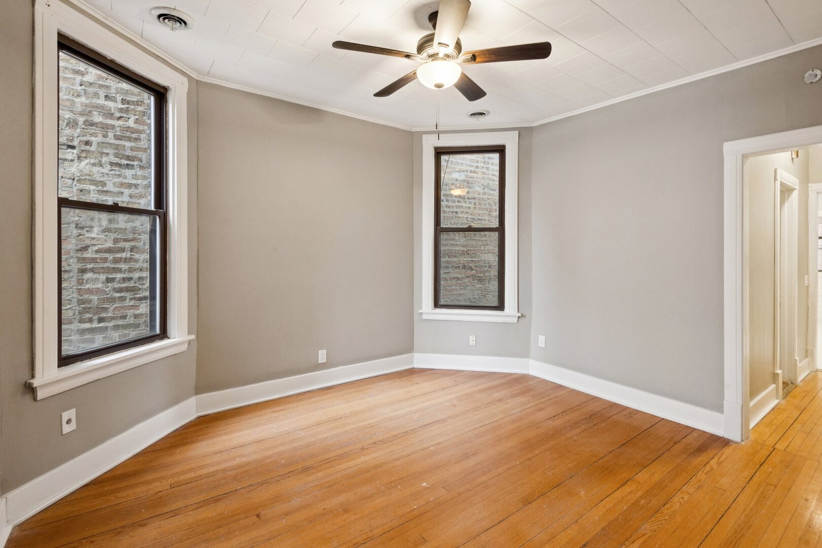 903 West Addison Street, Unit 1 Chicago, IL 60613 - Photo 16 of 25 a view of an empty room with window and wooden floor