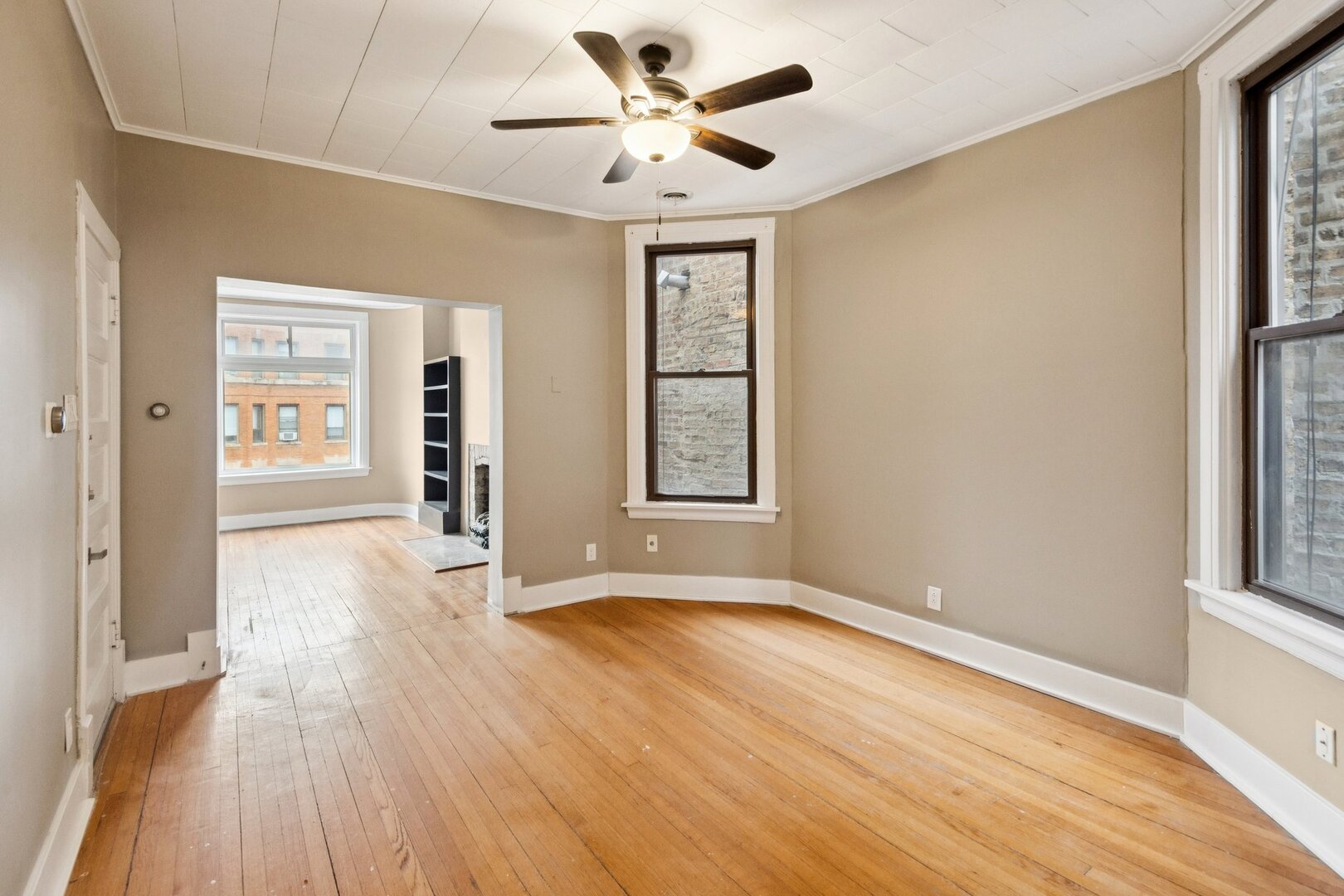 903 West Addison Street, Unit 1 Chicago, IL 60613 - Photo 17 of 25 a view of an empty room with a window and wooden floor