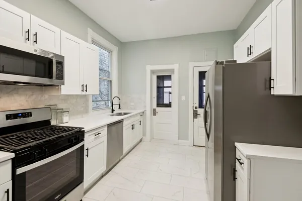 a kitchen with stainless steel appliances a stove a sink and a refrigerator