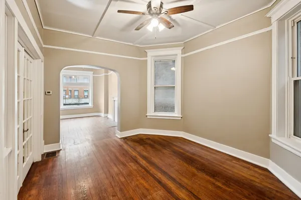 a view of an empty room with window and wooden floor