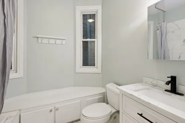 a bathroom with a sink a toilet and shower