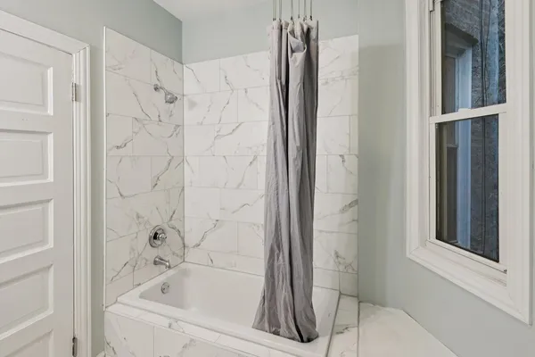 a bathroom with a bathtub and shower