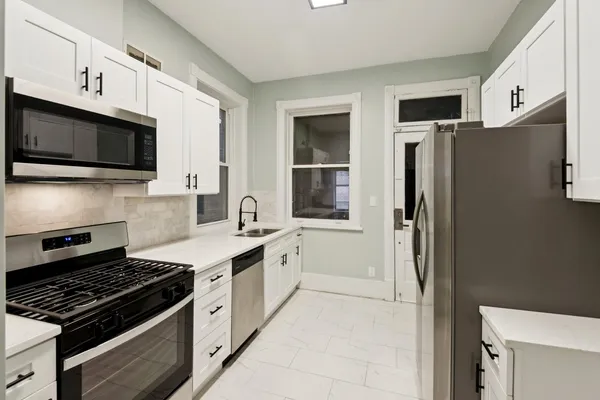 a kitchen with stainless steel appliances a refrigerator stove and microwave