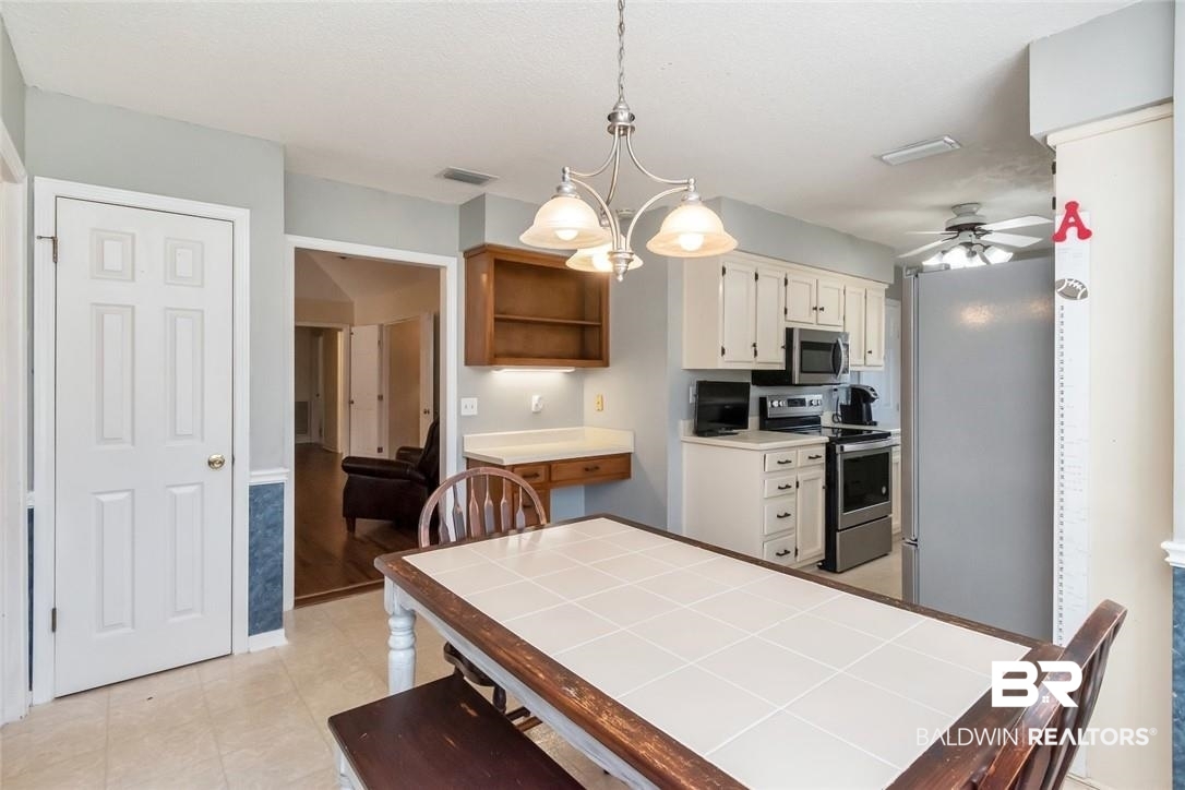 6601 Conde Court Mobile, AL 36695 - Photo 15 of 30 Dining area featuring ceiling fan with notable chandelier