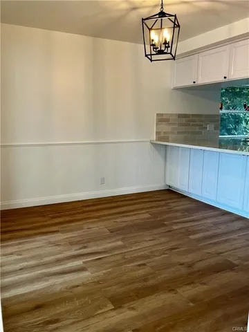 a view of a room with wooden floor and cabinets