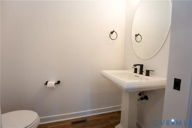 a bathroom with a sink mirror and toilet