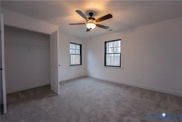 an empty room with window and ceiling fan