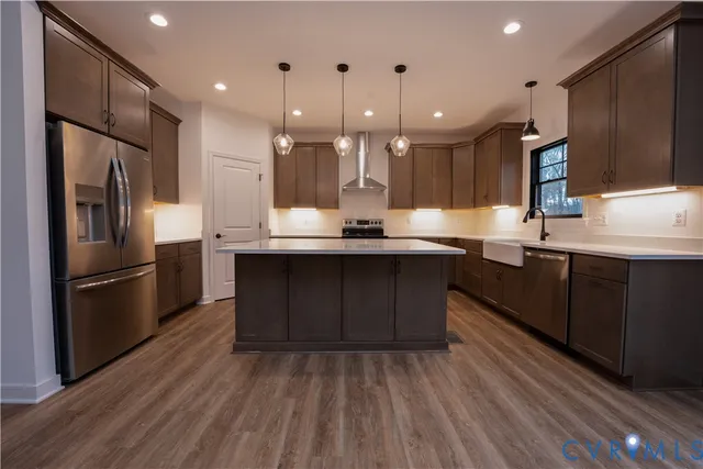 a kitchen with kitchen island granite countertop a sink appliances and cabinets