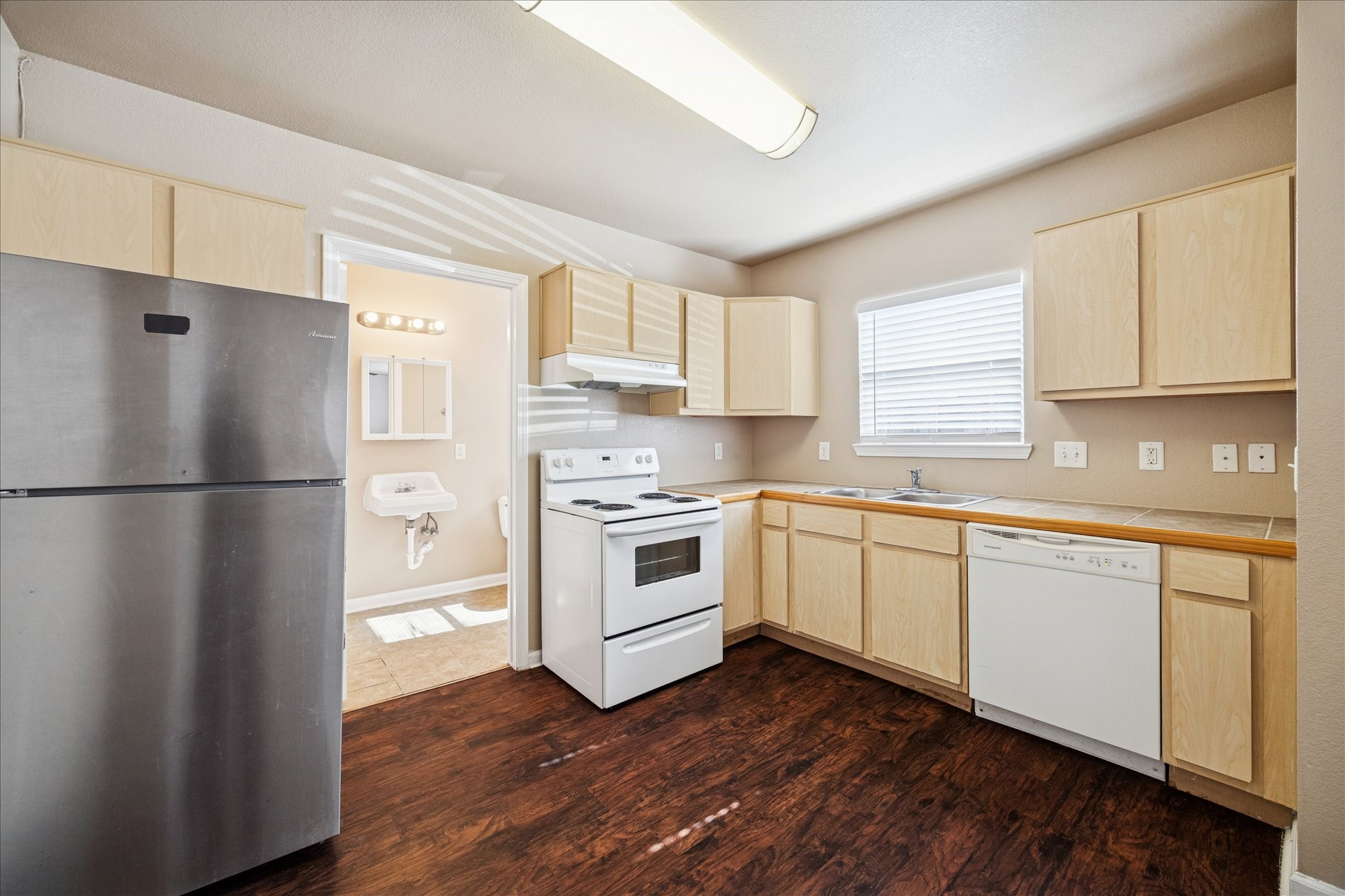 1225 West 25th Street, Unit 9 Houston, TX 77008 - Photo 2 of 11 a kitchen with white cabinets stainless steel appliances a sink and a window