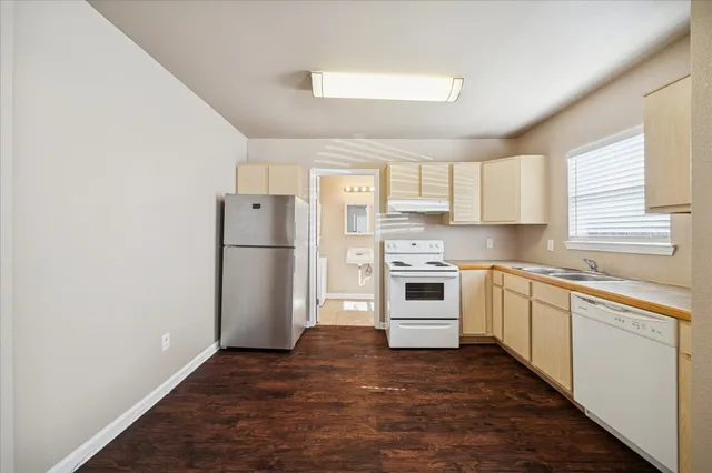 a kitchen with a refrigerator sink and cabinets