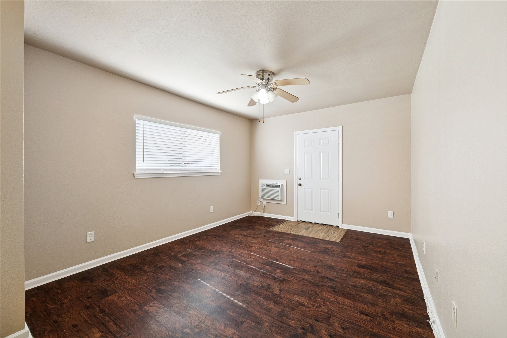 1225 West 25th Street, Unit 9 Houston, TX 77008 - Photo 7 of 11 an empty room with wooden floor ceiling fan and windows