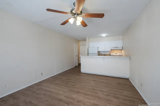 a view of a kitchen with wooden floor and a ceiling fan
