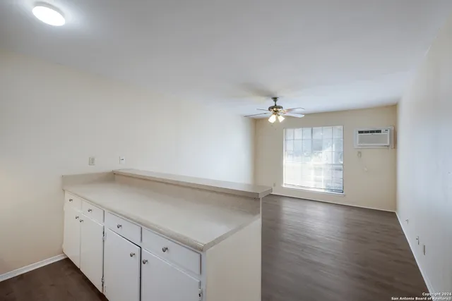 an empty room with wooden floor and cabinet