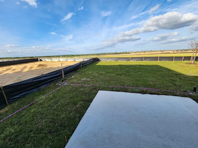 a view of a yard with a wooden fence