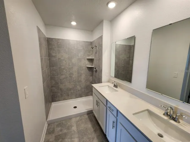 a bathroom with a double vanity sink mirror double and shower