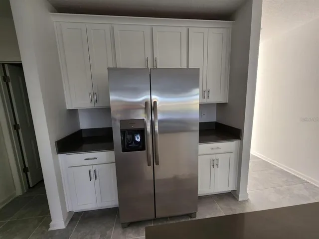 a kitchen with white cabinets and stainless steel appliances