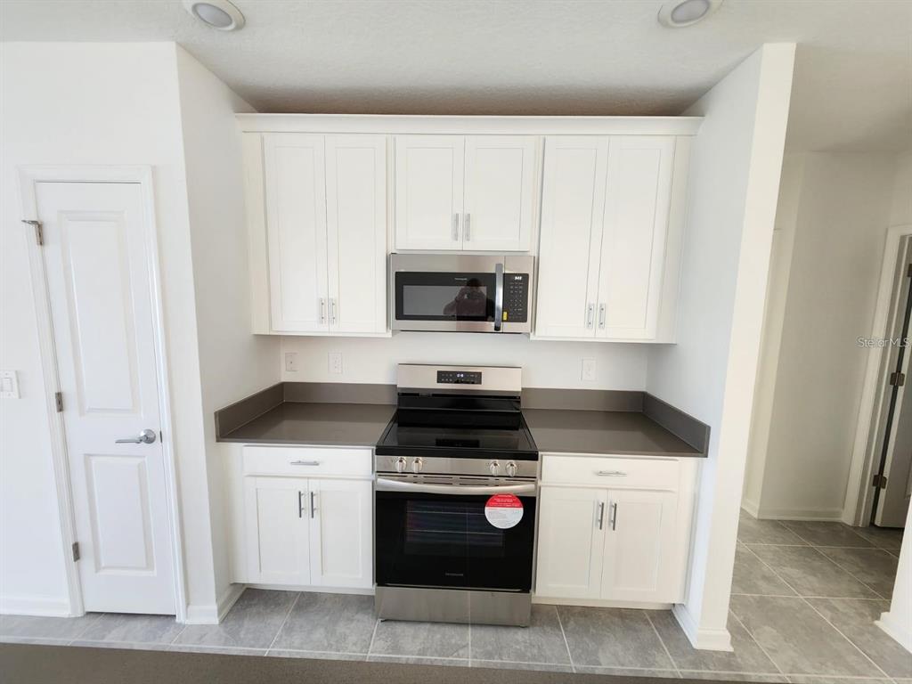 2713 Runners Circle Clermont, FL 34714 - Photo 8 of 30 a kitchen with granite countertop white cabinets and white appliances