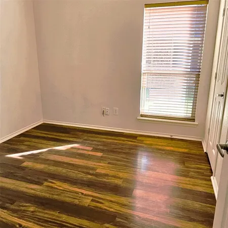 a view of a room with wooden floor and a window