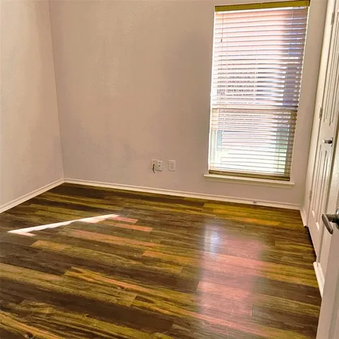 a view of a room with wooden floor and a window