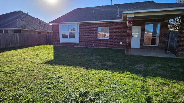 a view of a backyard with plants and large tree