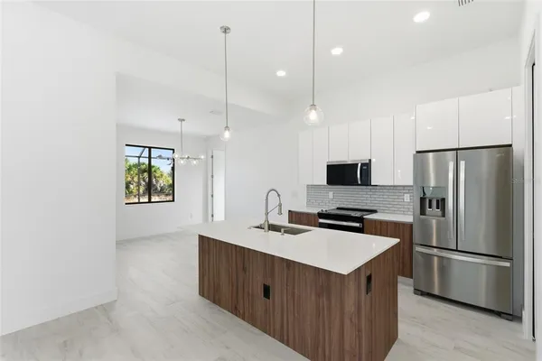 a kitchen with a sink refrigerator and microwave