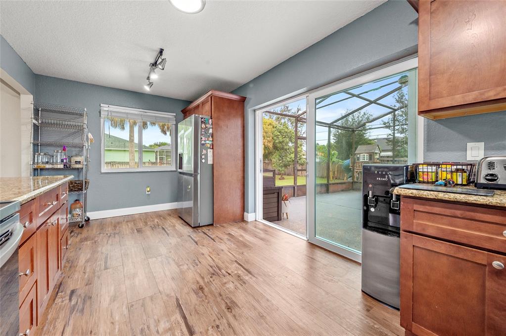 1041 Southwest General Patton Terrace Port St. Lucie, FL 34953 - Photo 13 of 39 a kitchen with granite countertop a stove and a wooden floors