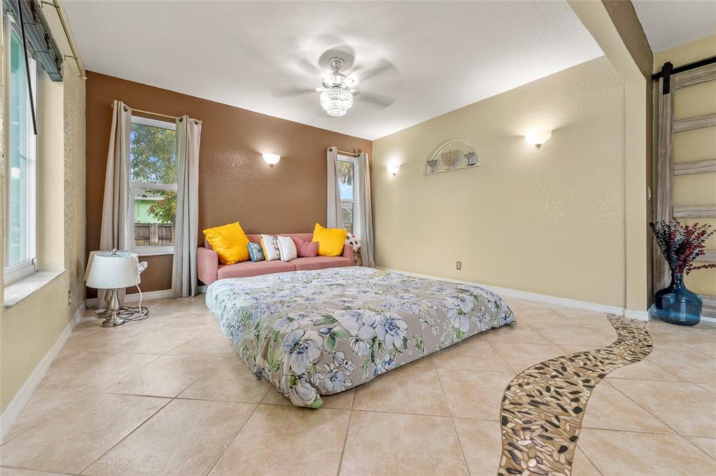1041 Southwest General Patton Terrace Port St. Lucie, FL 34953 - Photo 15 of 39 a bed room with a bed and a chandelier