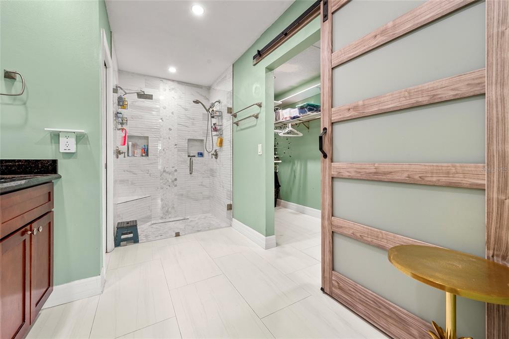 1041 Southwest General Patton Terrace Port St. Lucie, FL 34953 - Photo 17 of 39 a bathroom with a granite countertop sink a toilet and shower