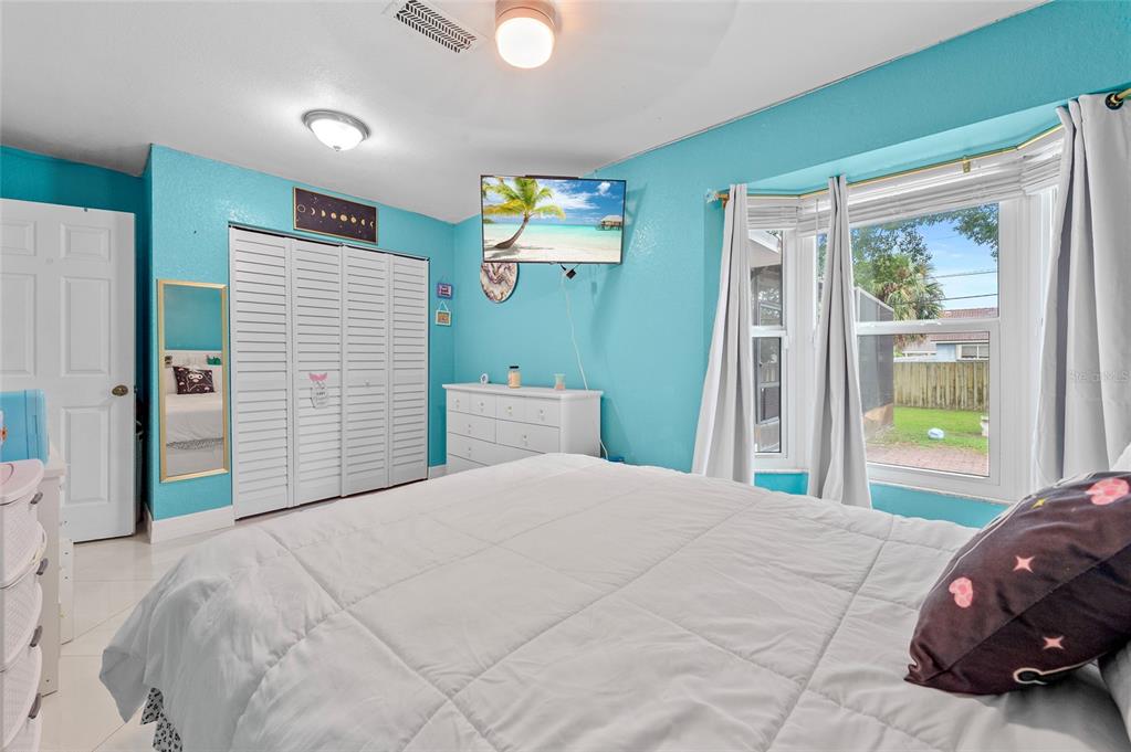 1041 Southwest General Patton Terrace Port St. Lucie, FL 34953 - Photo 19 of 39 a bedroom with a large bed and a large window