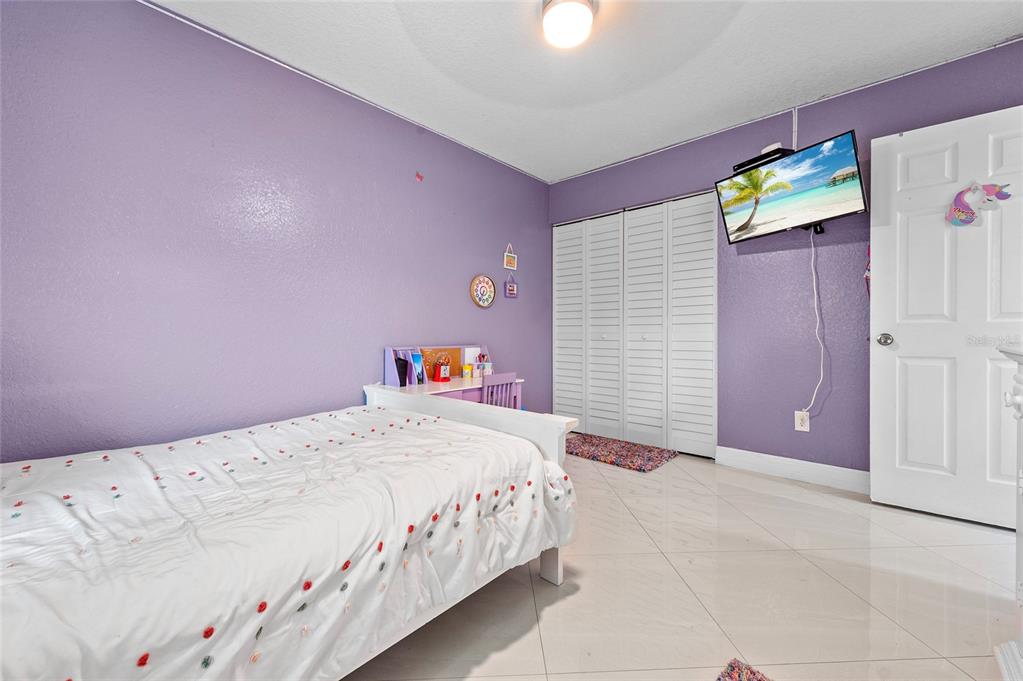 1041 Southwest General Patton Terrace Port St. Lucie, FL 34953 - Photo 22 of 39 a bedroom with a bed and a cabinets