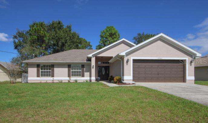 13505 Banner Road Spring Hill, FL 34609 - Photo 1 of 1 a front view of house with yard and green space
