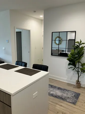 a kitchen with a sink a stove a refrigerator and white cabinets
