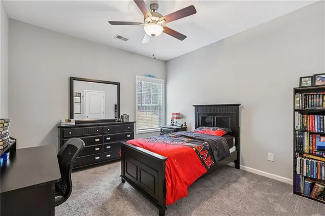 a bedroom with a bed dresser and a book shelf
