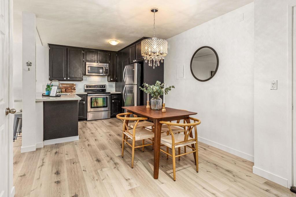 6780 Friars Road, Unit 129 San Diego, CA 92108 - Photo 6 of 50 a view of a dining room with furniture a chandelier and wooden floor