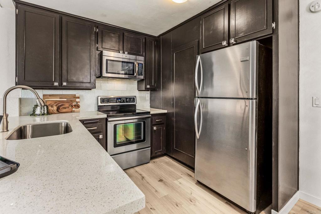 6780 Friars Road, Unit 129 San Diego, CA 92108 - Photo 8 of 50 a kitchen with granite countertop stainless steel appliances and refrigerator