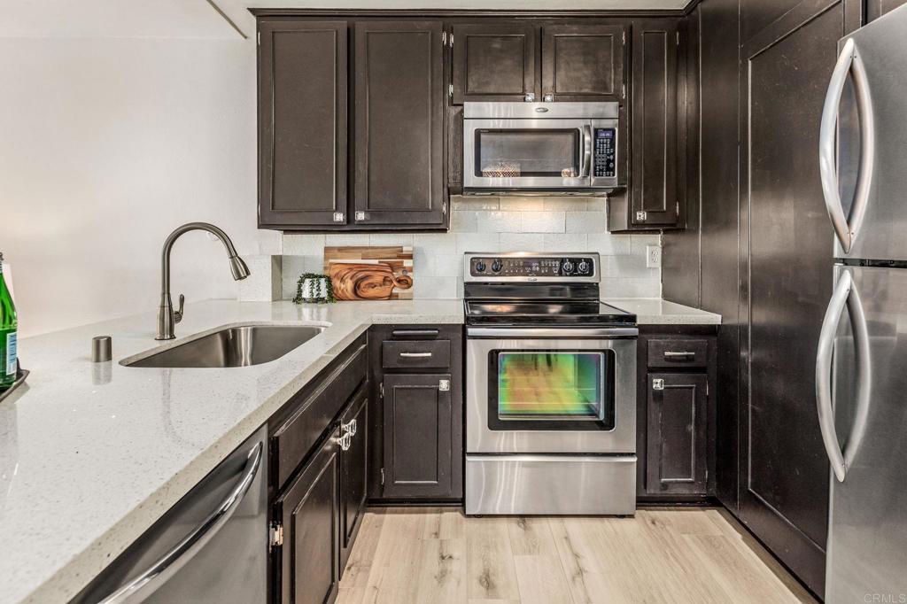 6780 Friars Road, Unit 129 San Diego, CA 92108 - Photo 9 of 50 a kitchen with stainless steel appliances granite countertop a refrigerator a stove a sink and dishwasher