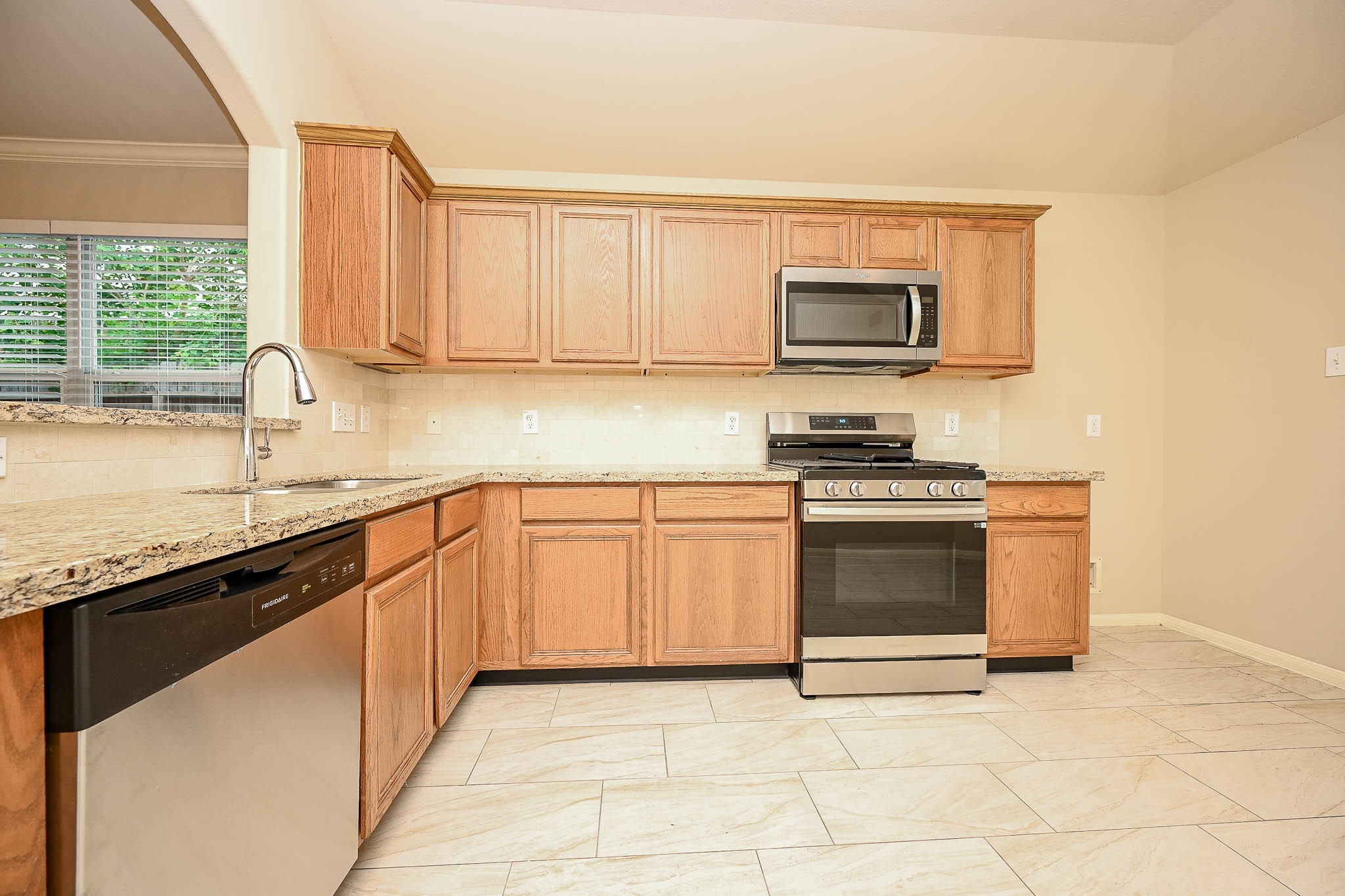 18518 Shadow Line Court Katy, TX 77449 - Photo 13 of 32 a kitchen with stainless steel appliances granite countertop a stove a sink and a microwave