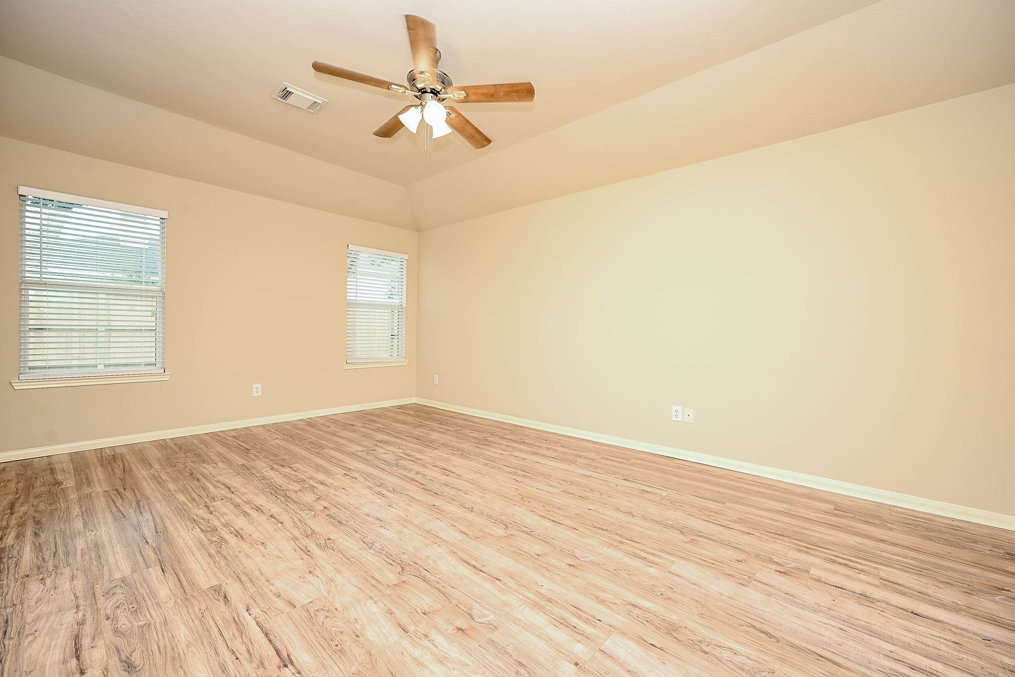 18518 Shadow Line Court Katy, TX 77449 - Photo 19 of 32 an empty room with wooden floor fan and windows