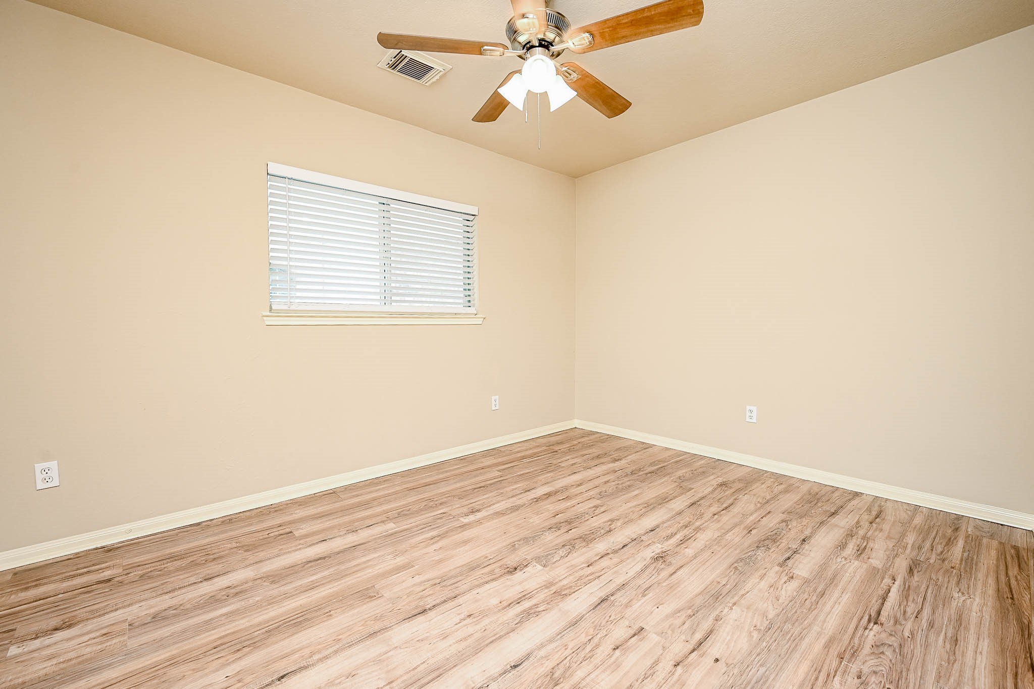 18518 Shadow Line Court Katy, TX 77449 - Photo 27 of 32 an empty room with wooden floor fan and windows