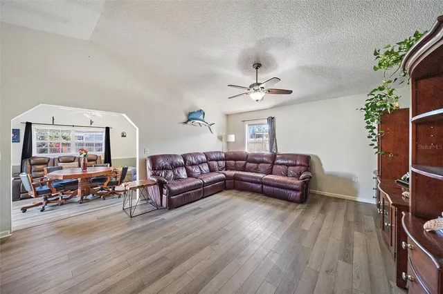 a living room with furniture a flat screen tv and a large window