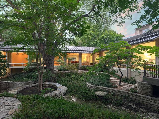 a view of a house with backyard and a tree