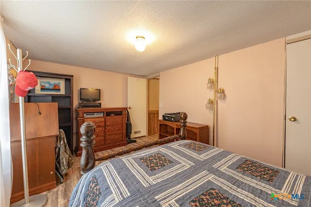 a bedroom with a bed and a refrigerator