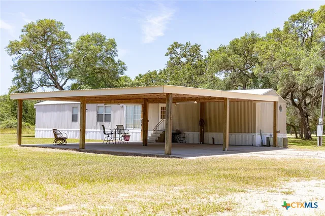 a view of a house with a swimming pool and sitting area