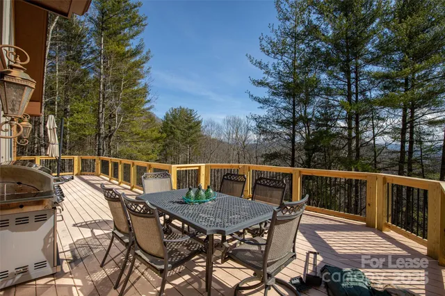 a balcony with wooden floor table and chairs